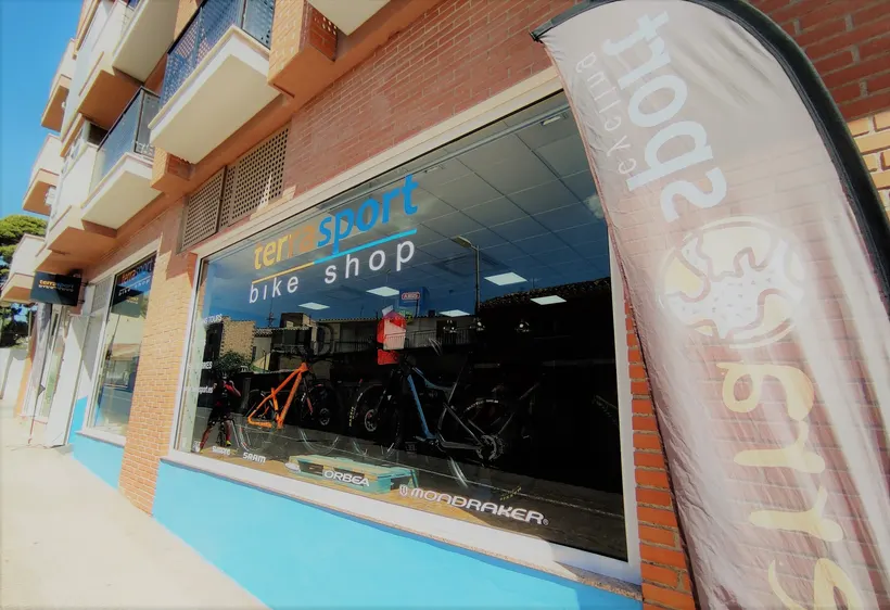 Fachada de la tienda con la bandera de Terra Sport Cycling