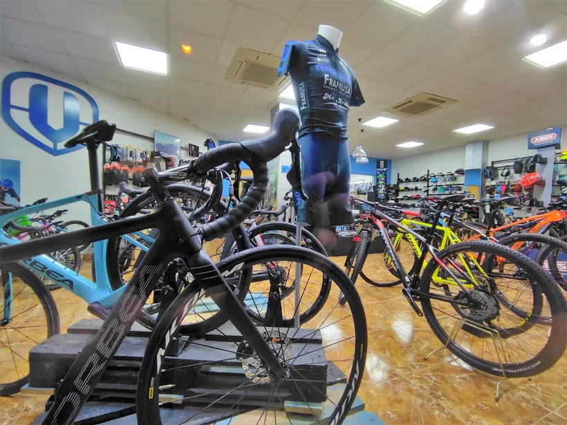 Interior de la tienda con bicicletas de carretera y maillots