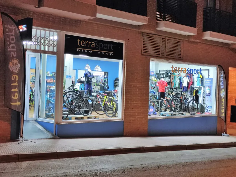 Fachada de Terra Sport Bike Shop iluminada de noche